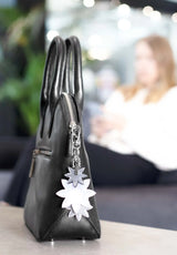 Lasessor Edelweiss heijastin - musta hopea - kukka - koruheijastin - laukkukoru -  asusteet - IHANA Store